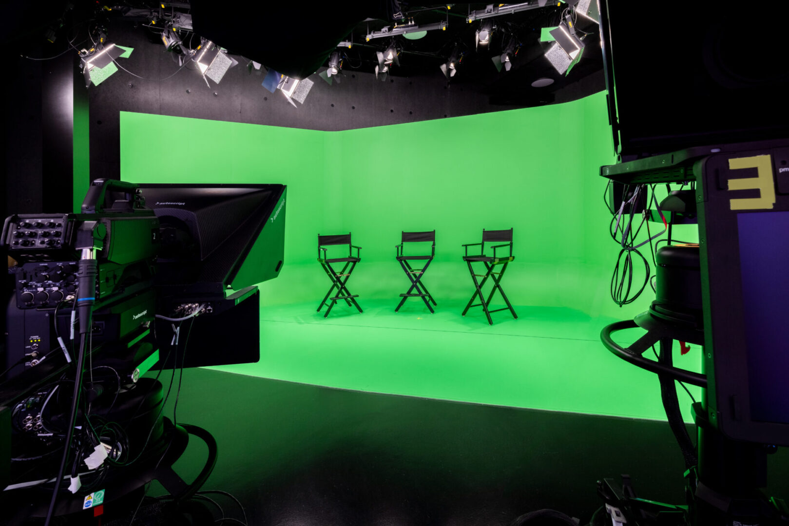 Green screen studio with three chairs.